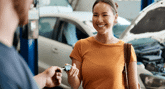 Happy woman receives her keys at a dealership