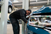 Volkswagen technician at work in VW dealership workshop