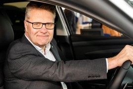 A man in a suit sitting in a car - Vertu Motors chief executive Robert Forrester 