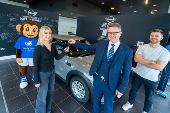 Raffle winner Emily Taylor with Vertu Motors chief executive Robert Forrester and Jordan Proctor from Charity Escapes