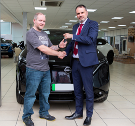 West Way Nissan Stockport master technician Christy Ashe receives his new Ariya EV from new car sales manager Ben Gellatly