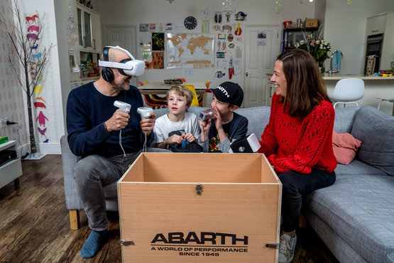 A family engaging with the Abarth 595 home test drive VR experience