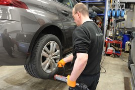A technician works on car in workshop