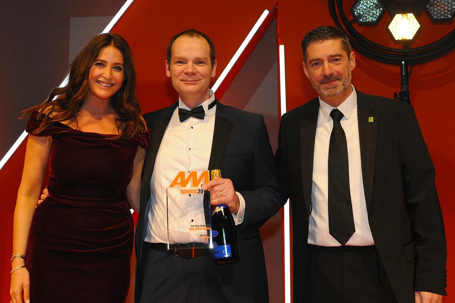 Arran Bangham, group vice-chairman,  RRG Škoda, accepts the award from Darren  Preddy, director – dealer sales, Rapid RTC, right and host Lisa Snowdon, left