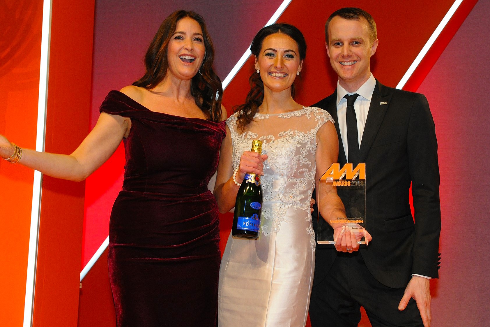Beth Jones, Arnold Clark Automobiles,  accepts the award from Liam Finney, head of commercial partners, EMaC, right and host Lisa Snowdon right