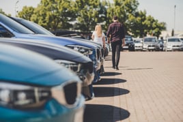 Car buyers walk across a dealership forecourt