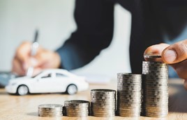 Men are putting coin and saint documents about cars with some coins calculator and car toy on desk.