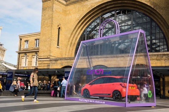 A Toyota Yaris in a giant shopping bag outside Kings Cross Station to promote cinch