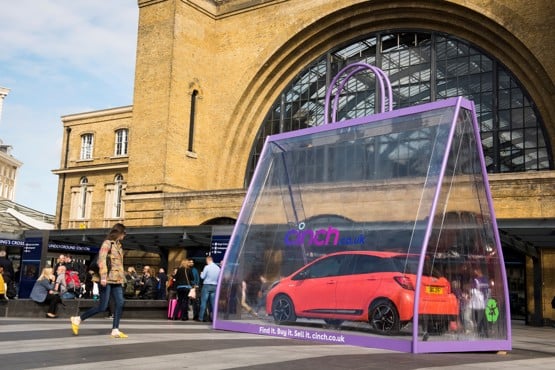 A Toyota Yaris in a giant shopping bag outside Kings Cross Station to promote cinch