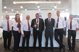 Craig Christopher receives champagne from his Robins & Day colleagues to celebrate 30 years' service