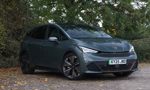A grey EV parked under trees (Cupra Born)