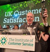 Suzuki GB director of automobile Dale Wyatt with the Institute of Customer Service (ICS) Awards Trusted Quality Provide trophy