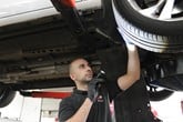 An automotive technician checking a vehicle's tyres