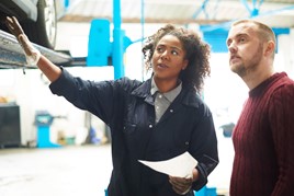 woman mechanic shows customer car