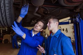 Apprentices working under a car