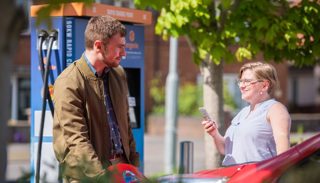 Person charging an electric vehicle (EV)