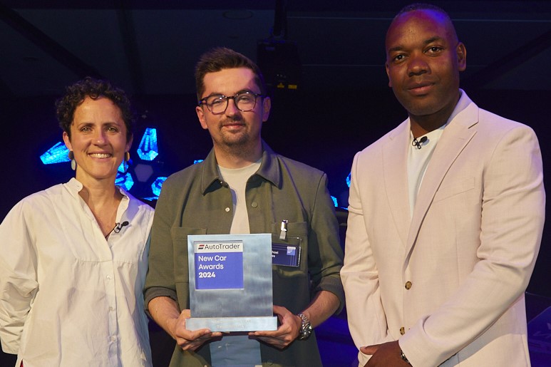 (centre) Michael Oates, Tesla UK's country sales and delivery manager, with the New Car of the Year Award