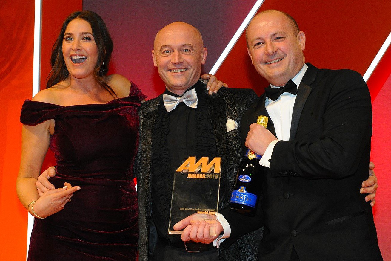 Neil Smith, operations director,  Imperial Cars, collects the award from  Kevin Brockbank, core sales director,  Santander Consumer Finance, right, and host Lisa Snowdon, left