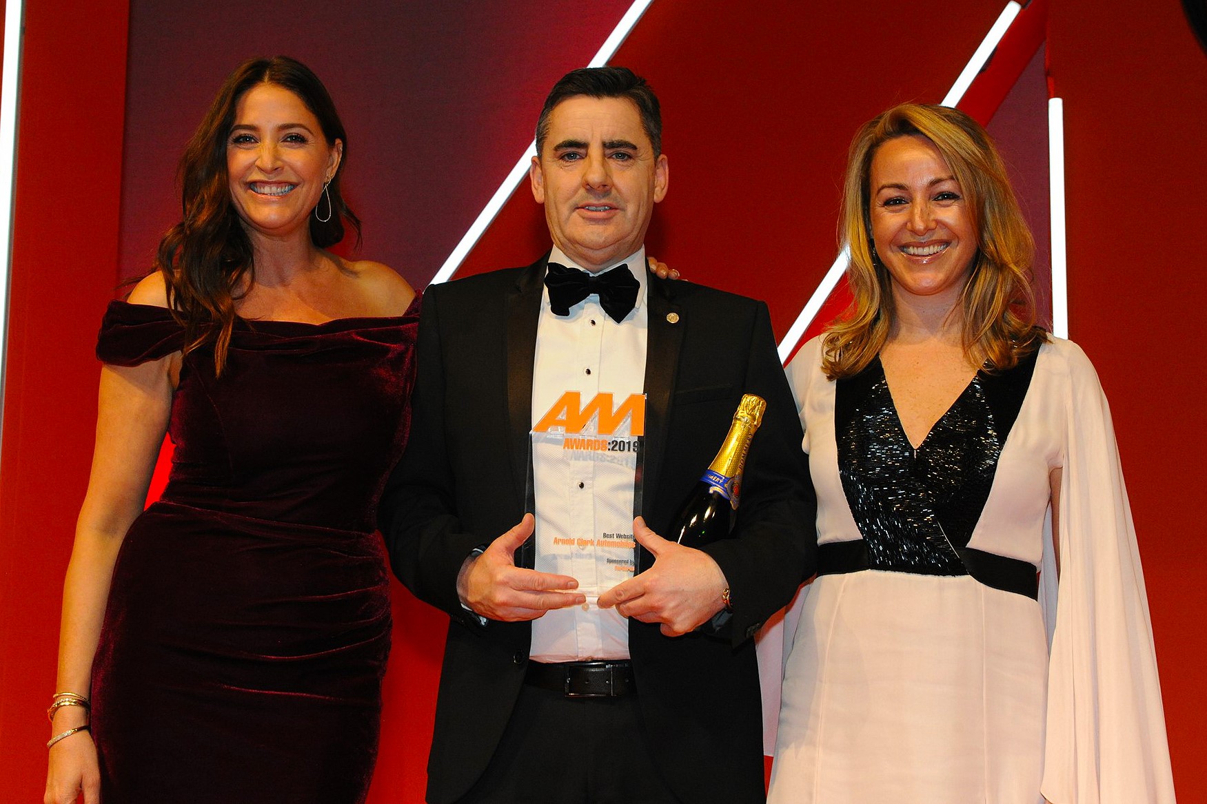 Russell Borrie, group franchise director, Arnold Clark Automobiles, accepts the award from Wendy Harris,  vice-president European sales, CarGurus, right, and host Lisa Snowdon, left