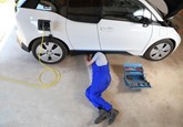 A car technician servicing a BMW i3 electric vehicle (EV)