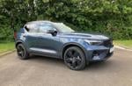 A blue SUV parked in front of greenery (Volvo XC40)